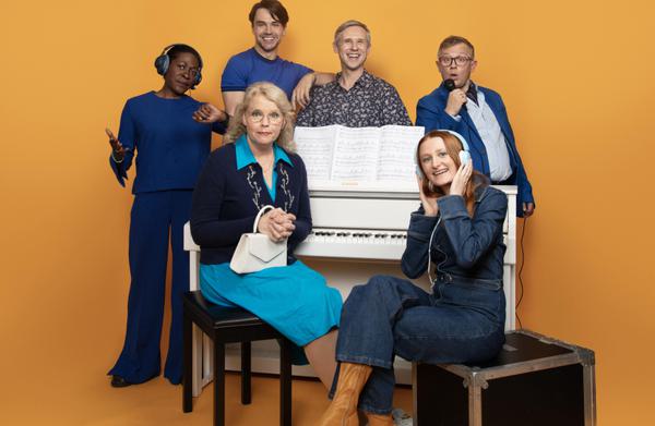 The cast of The Way Old Friends Do around a piano on a bright yellow background.