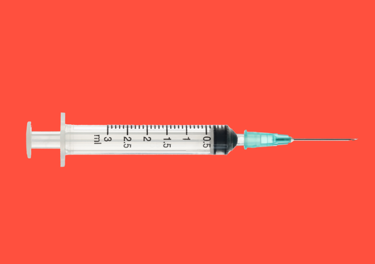 An injection needle against a bright orange background.