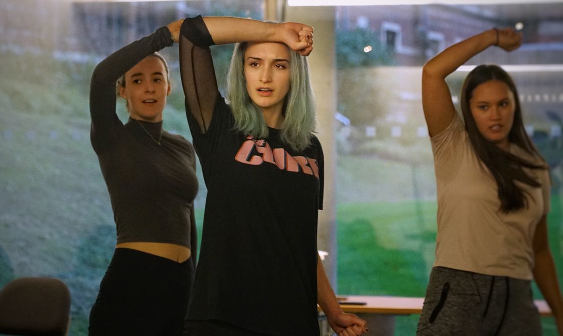 Three people all pose with their forearms raised up to the foreheads.