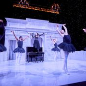 Cast of A Midsummer Night's Dream Fairy Queen Titania with ballet dancers around her while snow gently falls on stage.