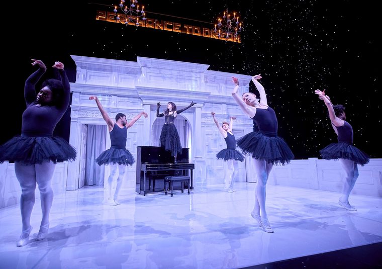 Cast of A Midsummer Night's Dream Fairy Queen Titania with ballet dancers around her while snow gently falls on stage.