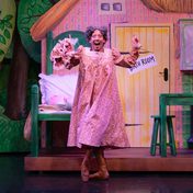 Ommaira Kanga Perez dressed as the grandmother set in a cottage backdrop.