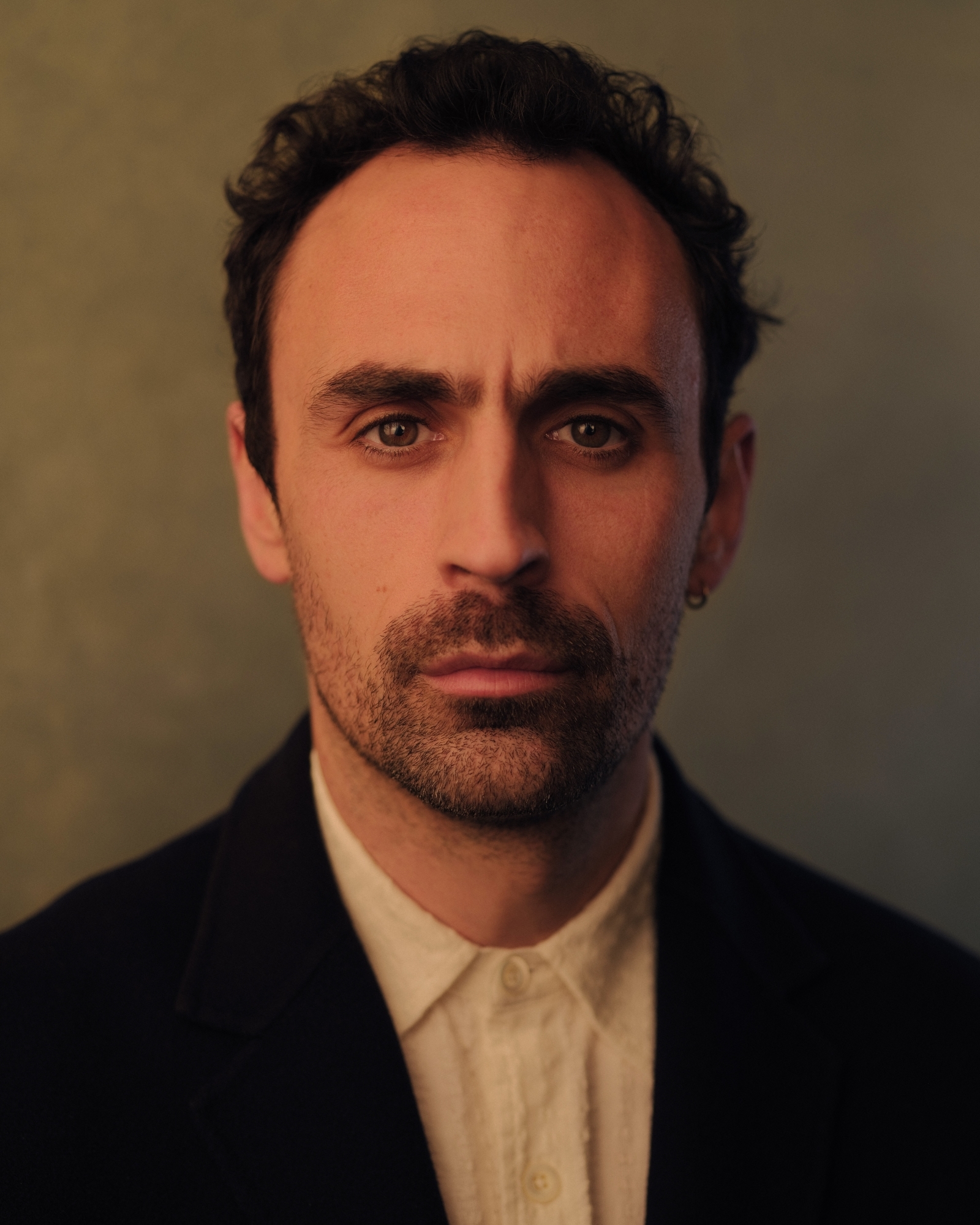 Alex Mugnaioni profile image against a brown-orange background.