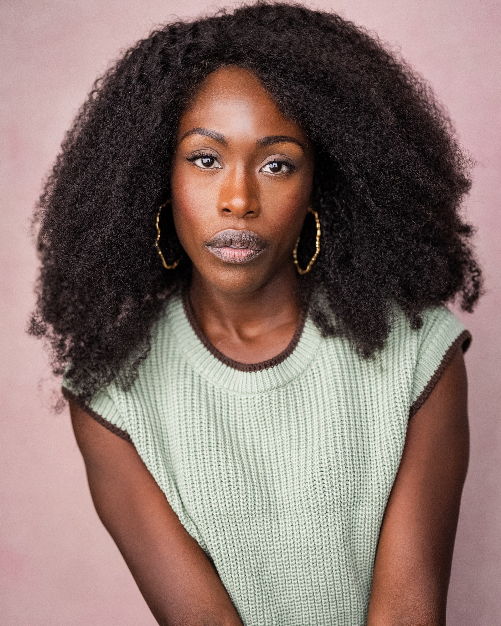 Gloria Onitiri profile image against a pink background.