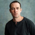 Tim Delap profile image against a green-grey background.