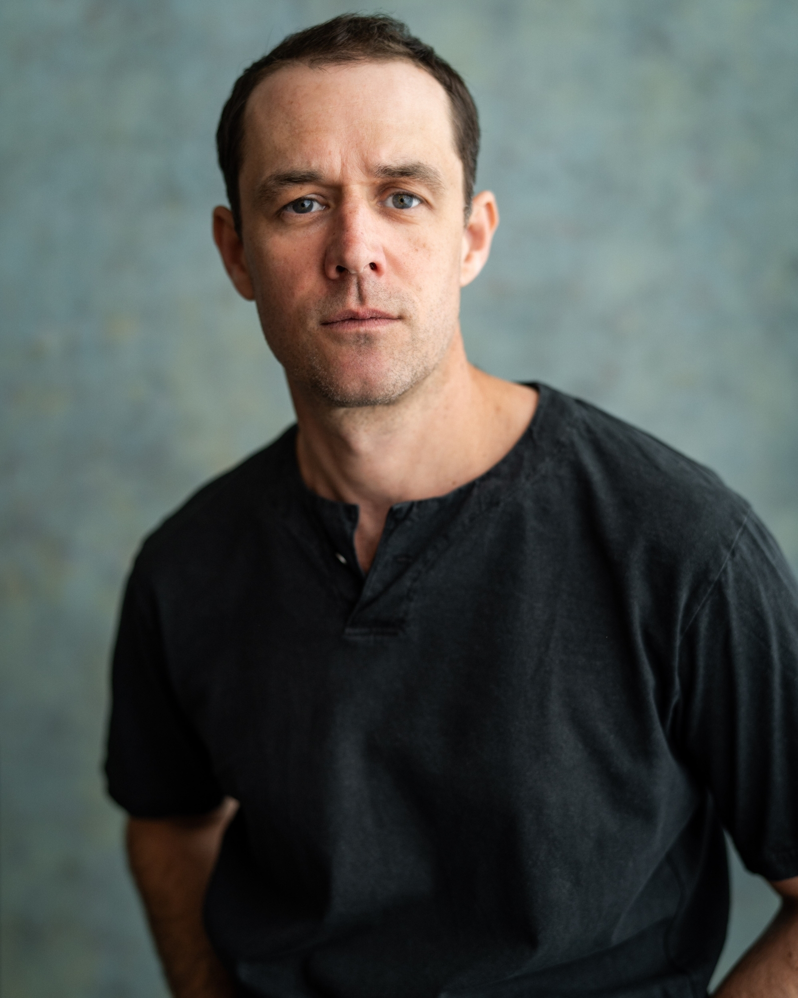 Tim Delap profile image against a green-grey background.