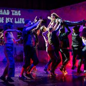 An actor being lifted up recreating the Dirty Dancing scene with the projection of 'I've had the time of my life' in the background.