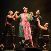 A dramatic pose struck by an actress in a sari with dancers behind applauding her.