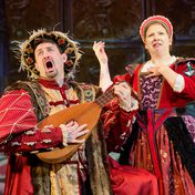 Two actors in tudor costume sing dramatically to a lute as Henry VIII and Catherine of Aragon, who looks mildly disgusted.