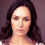 Profile image of Juliet Aubrey against a dark maroon background.