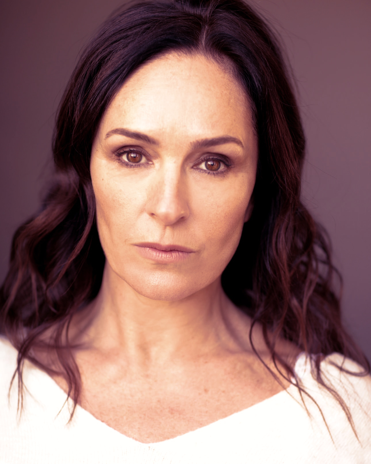 Profile image of Juliet Aubrey against a dark maroon background.