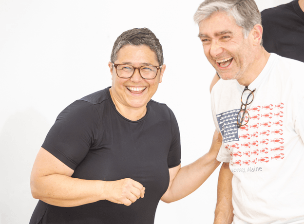 Two actors laughing during rehearsals for The Caucasian Chalk Circle.