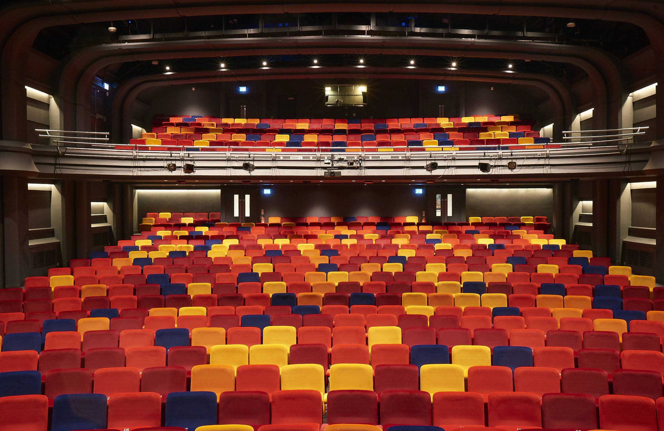 A wide shot of OP's auditorium. There are seats in red, orange, purple and yellow.