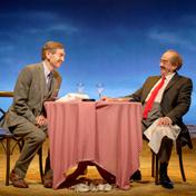 Two men sat at a round restaurant table.