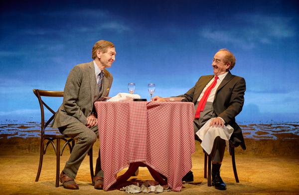 Two men sat at a round restaurant table.