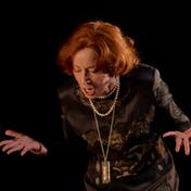 A woman looks down with her palms out in front of her.