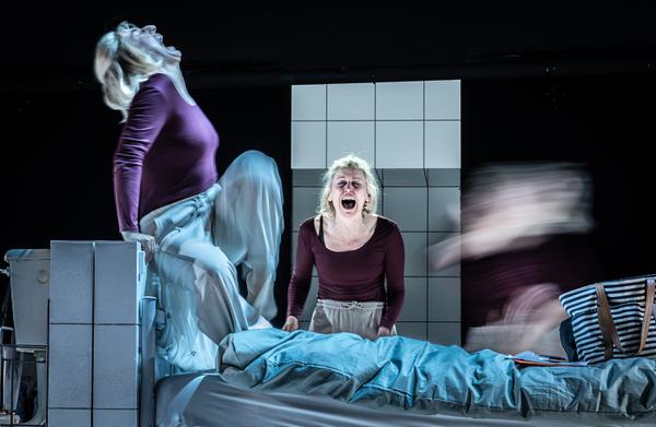 A woman screams as the side of a hospital bed as a blurred version of herself rises from the covers.