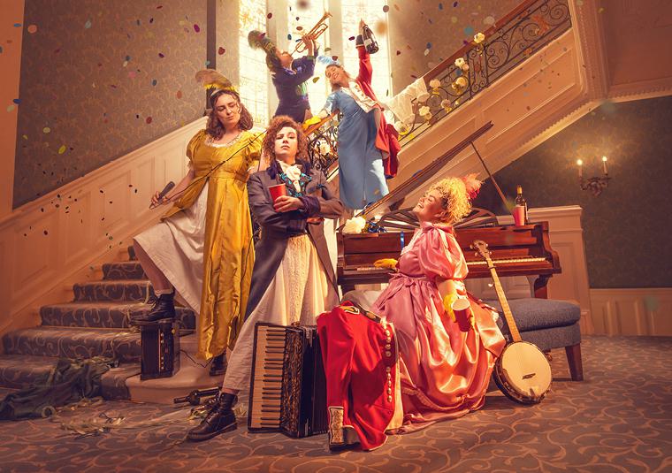 Five people wear 1800s finery, sprawled across a staircase of a London townhouse, instruments surround them.