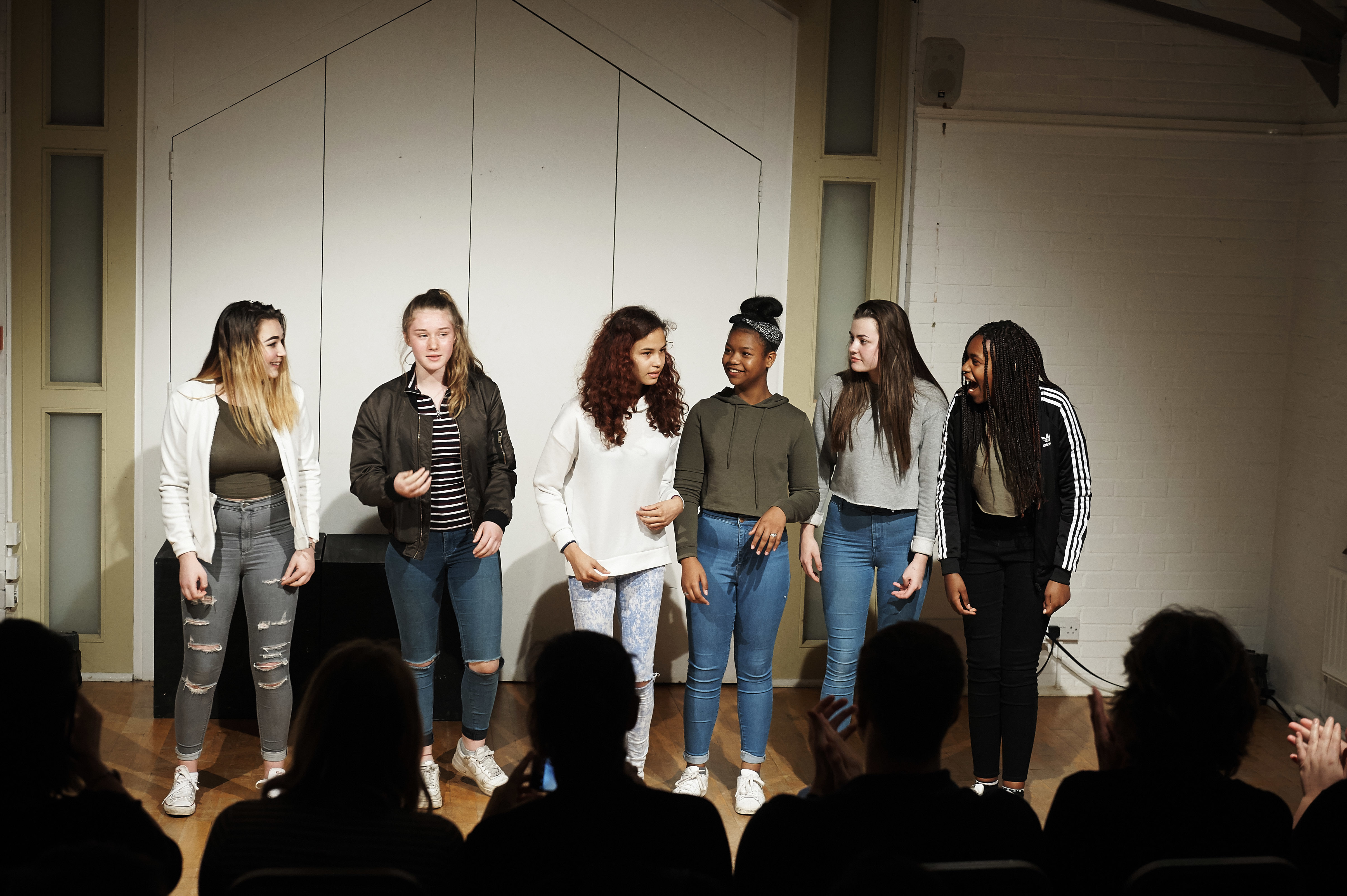 A group of teenagers performing a Play