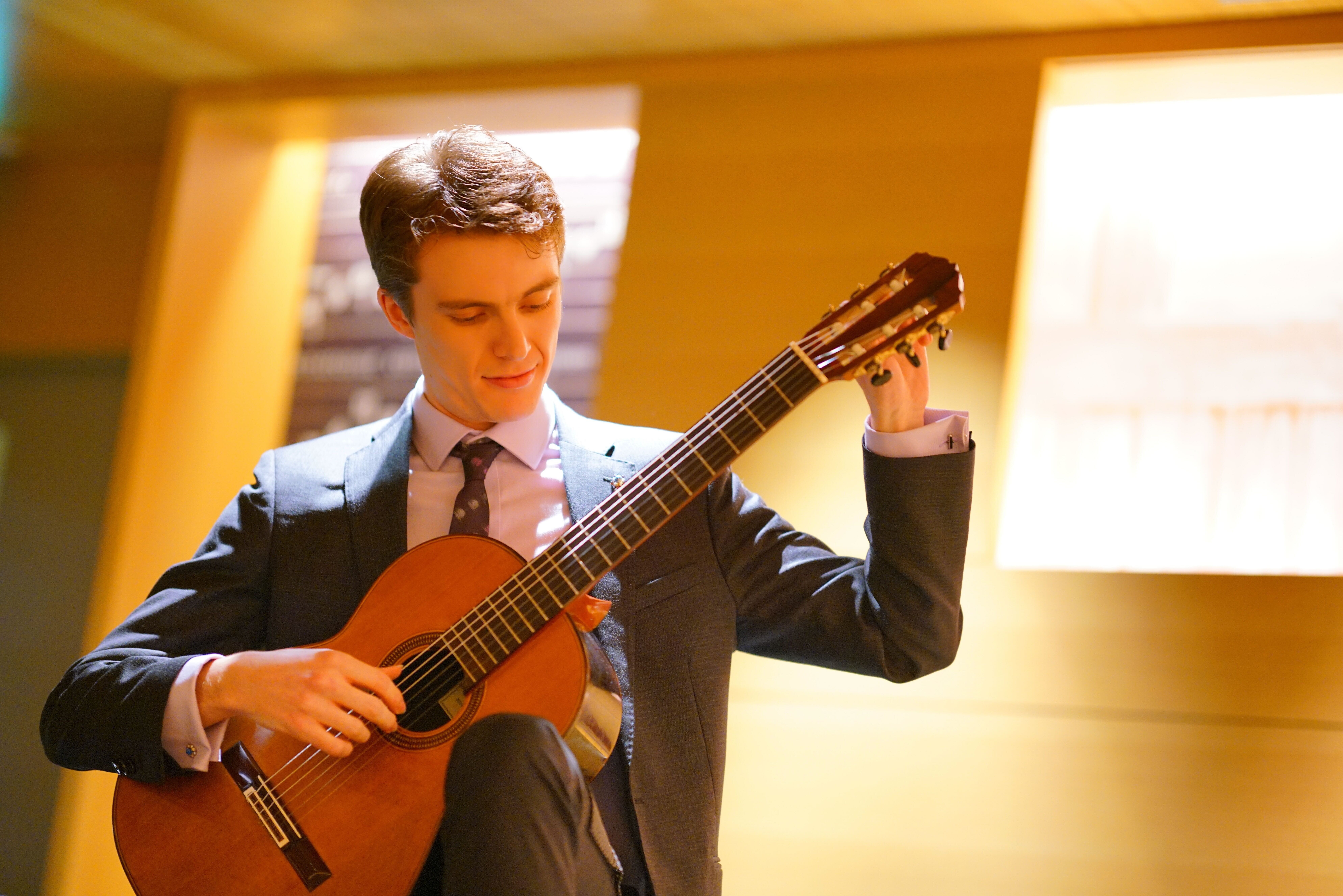 A performer tuning a guitar