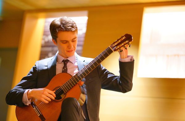 A performer tuning a guitar