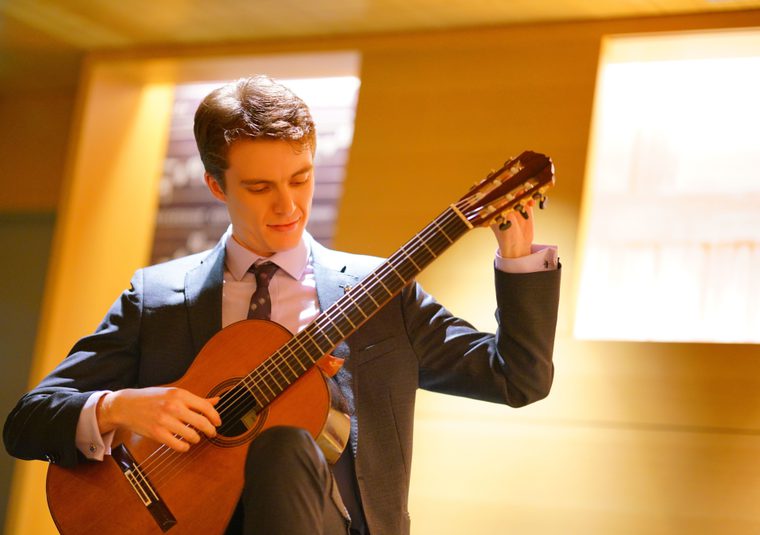 A performer tuning a guitar