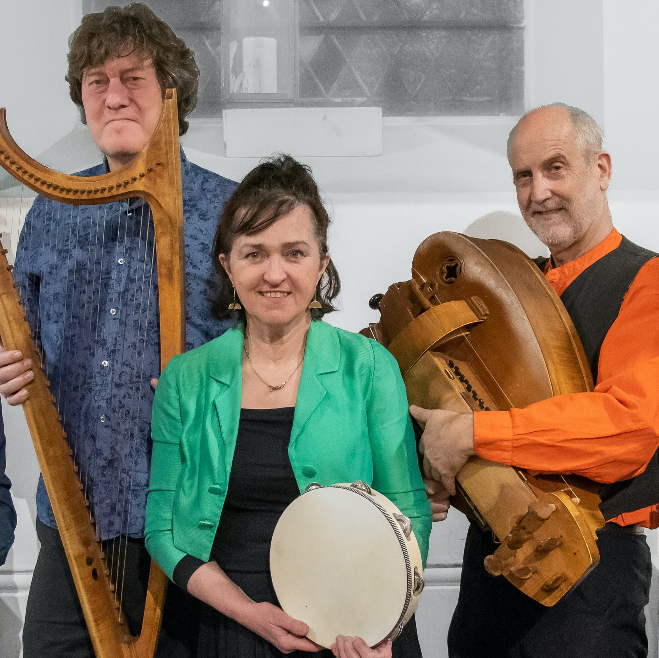 The performers holding their instruments and looking at the camera