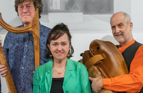 The performers holding their instruments and looking at the camera