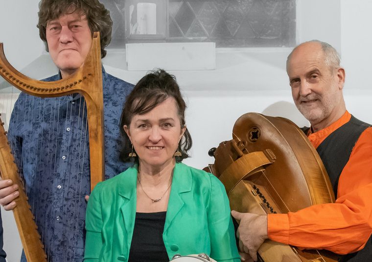 The performers holding their instruments and looking at the camera