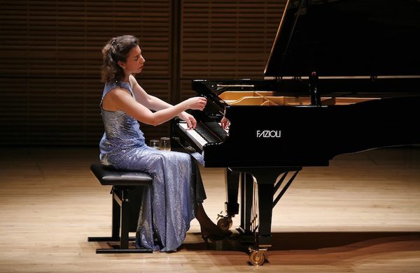 The performer playing an instrument on a stage