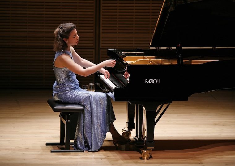 The performer playing an instrument on a stage