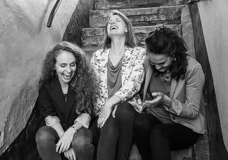 Three performers sitting on staircase
