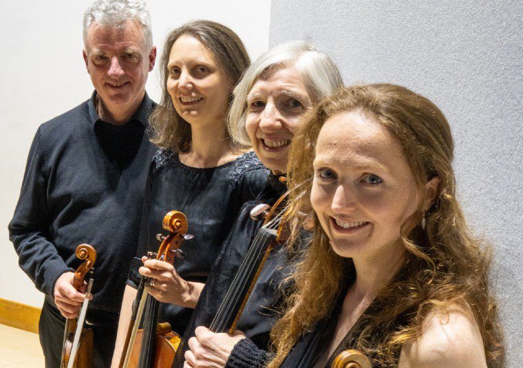 The performers looking at the camera and holding their instruments