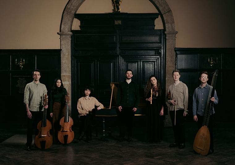 Performers standing in front of an arched door
