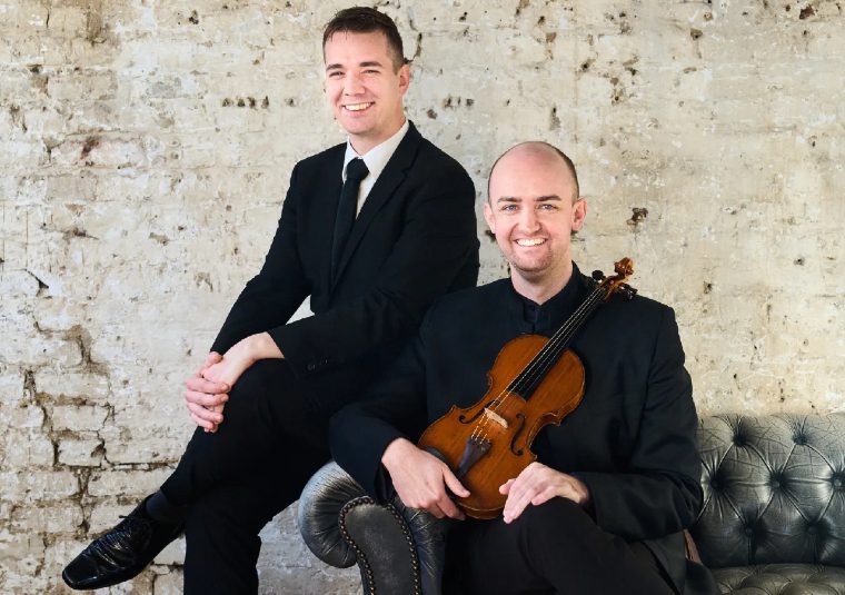 Performers holding an instrument and looking at the camera