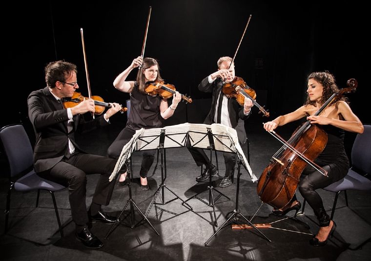 The performers playing their instruments on a stage