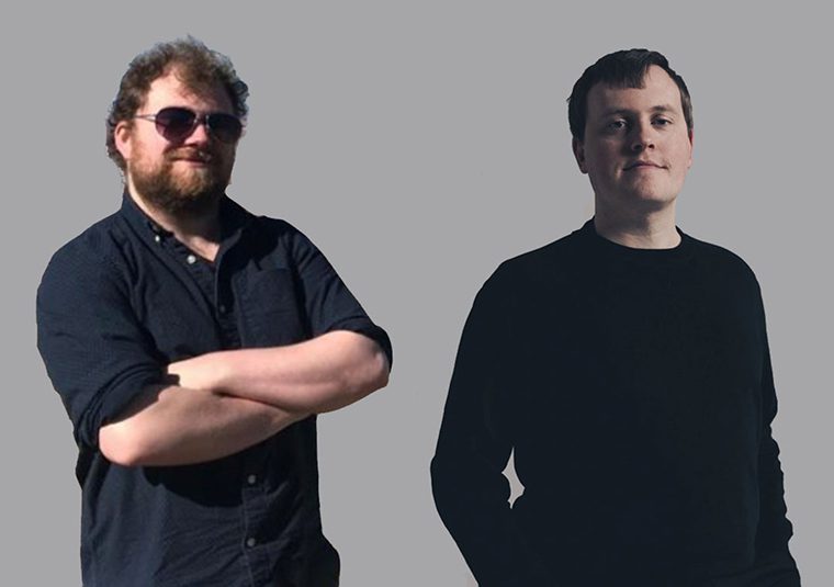 The performers standing against a gray background, facing the camera