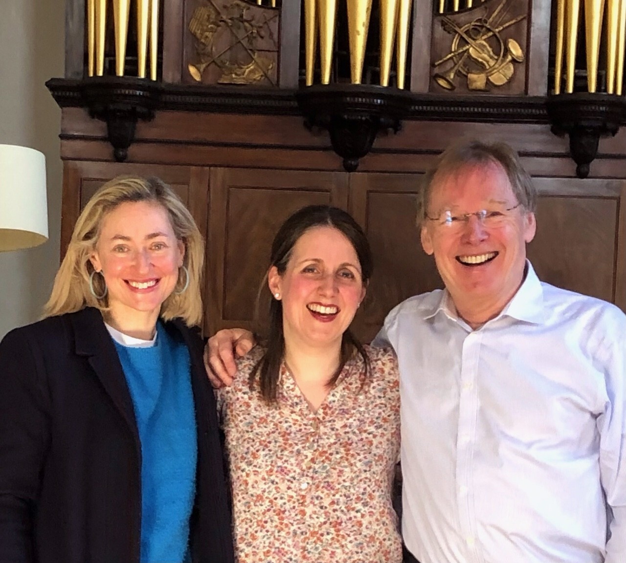 Performers standing in front of an organ