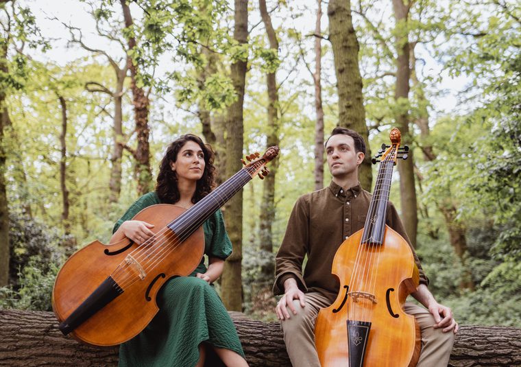Performers holding instruments and sitting in a wood