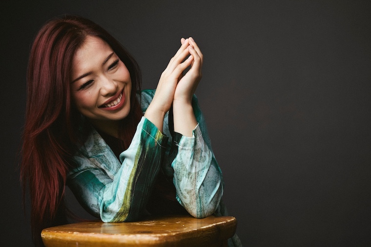 The performer leaning against a stool and laughing