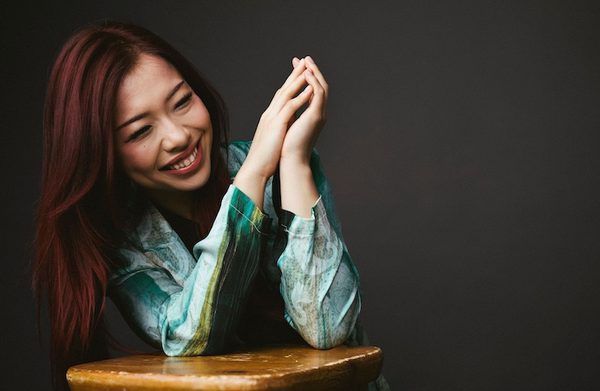 The performer leaning against a stool and laughing