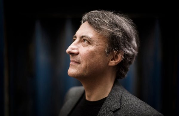 Performer standing against a dark blue background