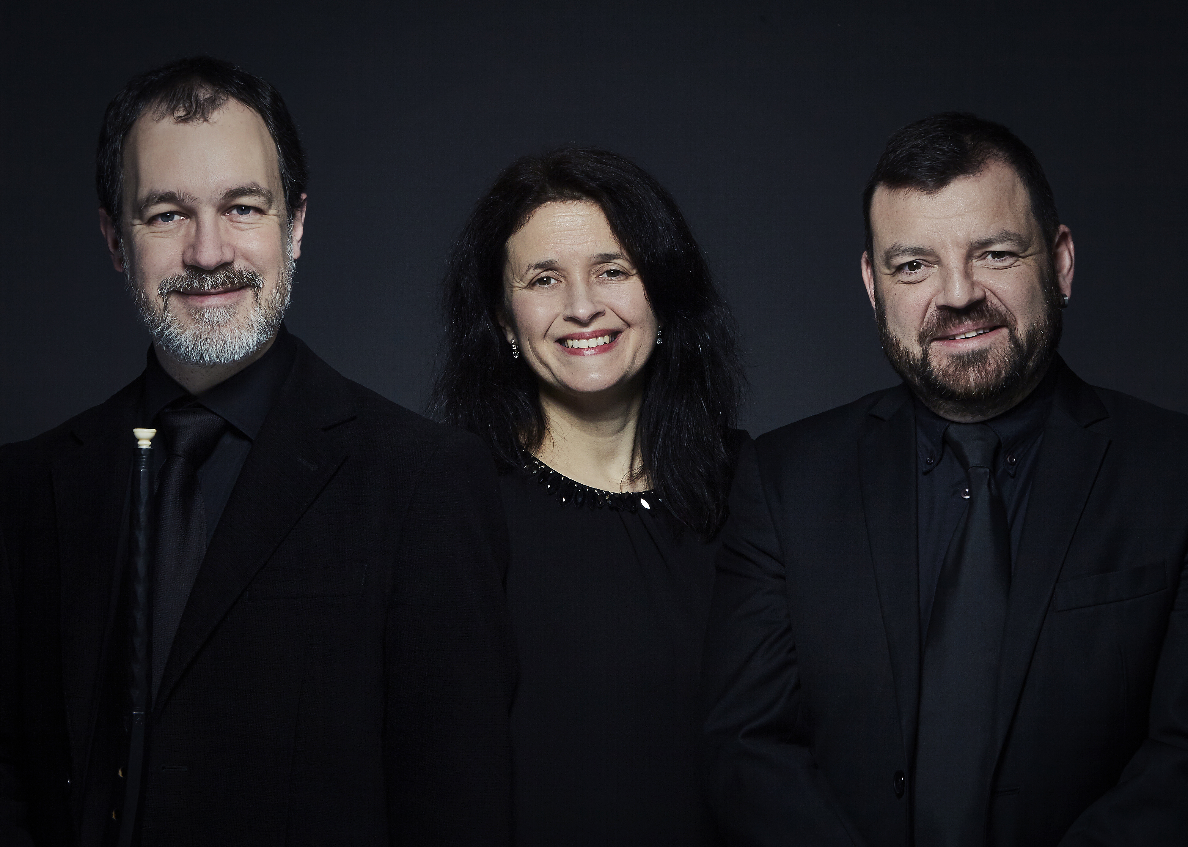 The performers looking at the camera against a dark background