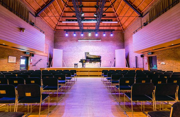 The interior of the JdP Music Building set for a concert with piano on-stage
