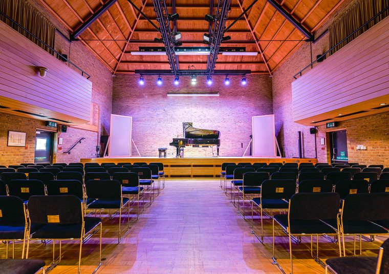 The interior of the JdP Music Building set for a concert with piano on-stage
