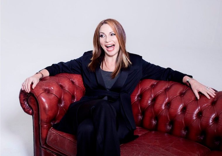 The performer sitting on a sofa