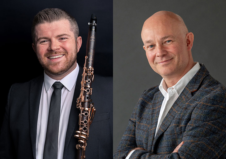 The performers standing against a gray background, facing the camera