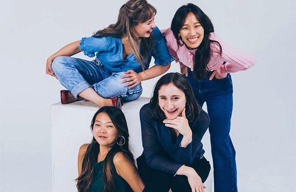 The performers, against a gray background, facing the camera