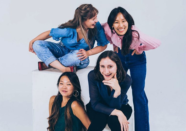 The performers, against a gray background, facing the camera