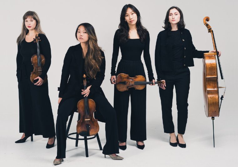 The performers holding their instruments in a white space